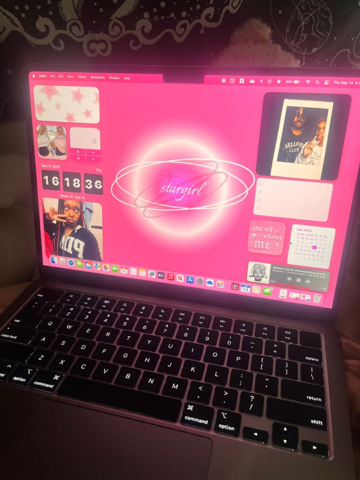 an open laptop computer sitting on top of a wooden table next to a wallpaper