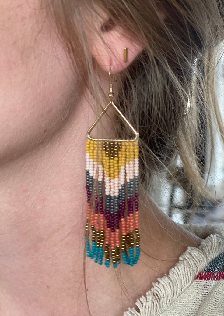 These Triangle Fringe Beaded Earrings are the perfect way to accessorize any look. Crafted from quality beads, they offer a lightweight and comfortable fit. With a unique triangle shape and detailed dangling fringe, you can make a stylish statement. Length: 3.75" Color: gold, mustard yellow, pink, silver, burgundy, terracotta and teal Triangle Beaded Earrings, Fringe Earring Pattern, Fringe Beaded Earrings, Earring Patterns, Bead Jewelry, Triangle Shape, Seed Bead Jewelry, Fringe Earrings, Jewelry Diy