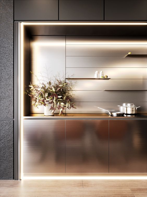 a modern kitchen with stainless steel cabinets and potted plants on the countertop in front of it