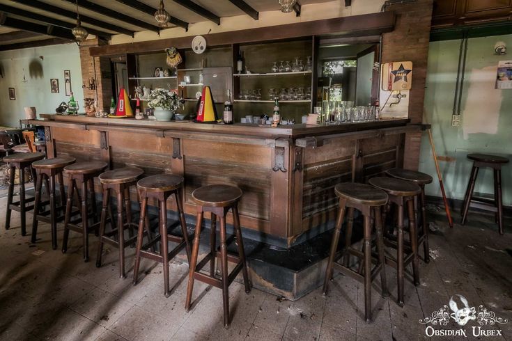 an old fashioned bar with wooden stools