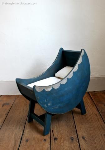 a blue and white chair sitting on top of a wooden floor next to a wall