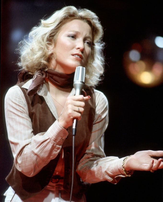 a woman holding a microphone in her right hand