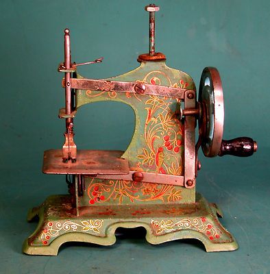 an old sewing machine is sitting on a table next to a blue wall with a green background