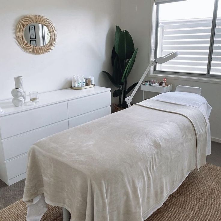 a white bed sitting next to a window in a bedroom