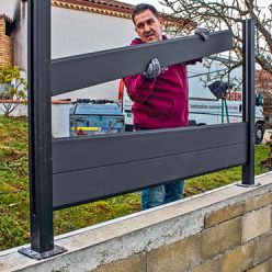 a man standing behind a black metal sign