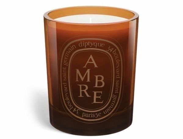 an orange glass candle with the words, ambree on it and a white background