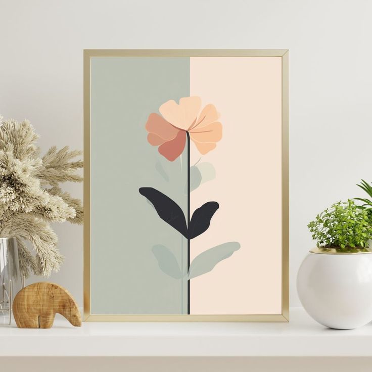 a white shelf topped with a vase filled with plants and a framed art print on top of it