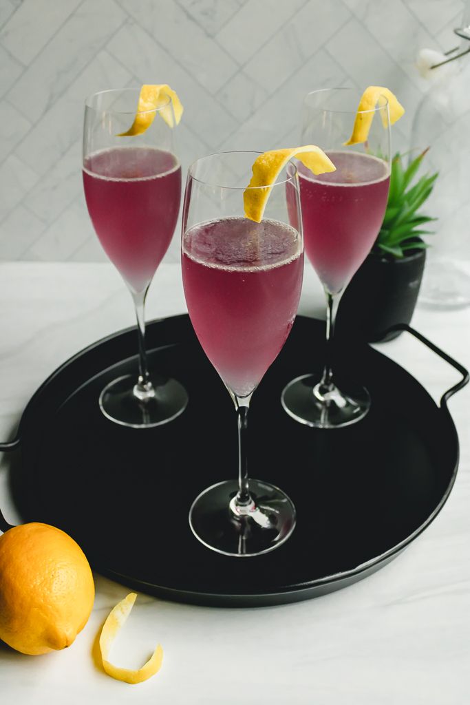 three glasses of pink lemonade on a black tray