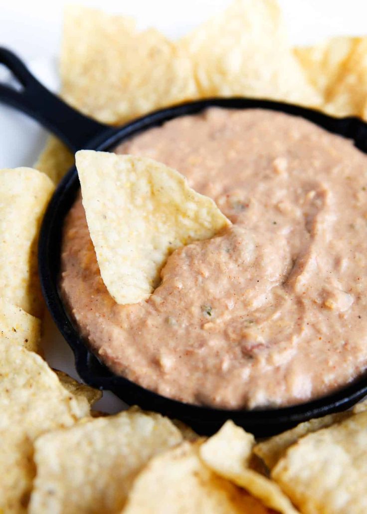 a black bowl filled with chips and dip