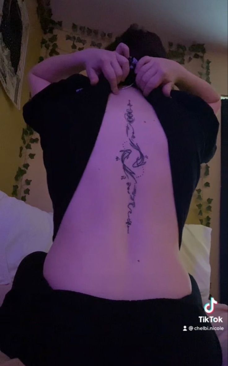 the back of a woman's body with a tattoo on her lower half and upper part