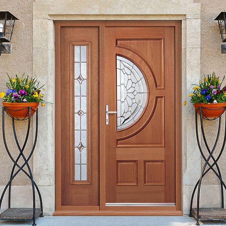 the front door is decorated with potted plants and two planters on either side