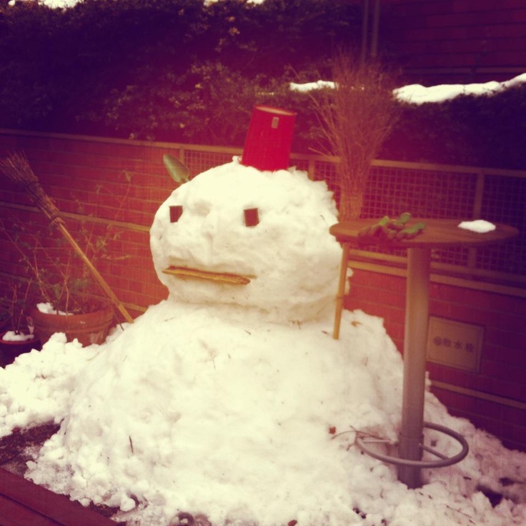 a snowman sitting on top of a pile of snow