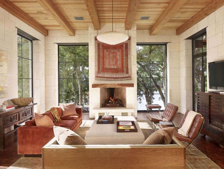 a living room filled with furniture and a fire place in the middle of a room