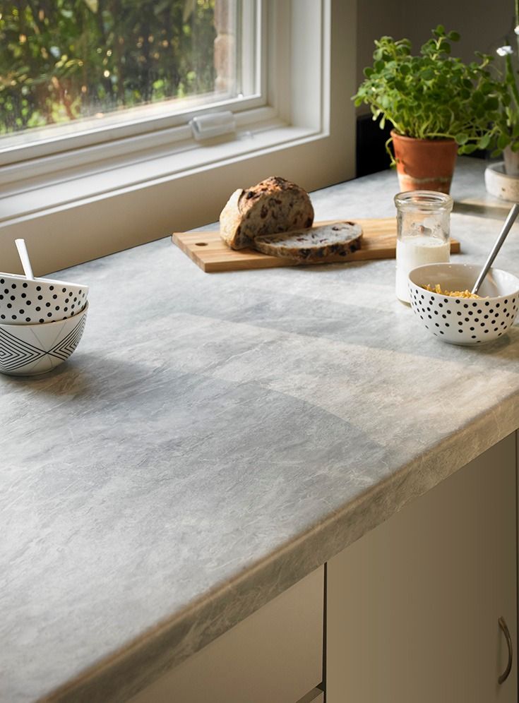 a kitchen counter with two bowls and a loaf of bread sitting on top of it