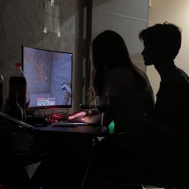 two people sitting in front of a computer screen