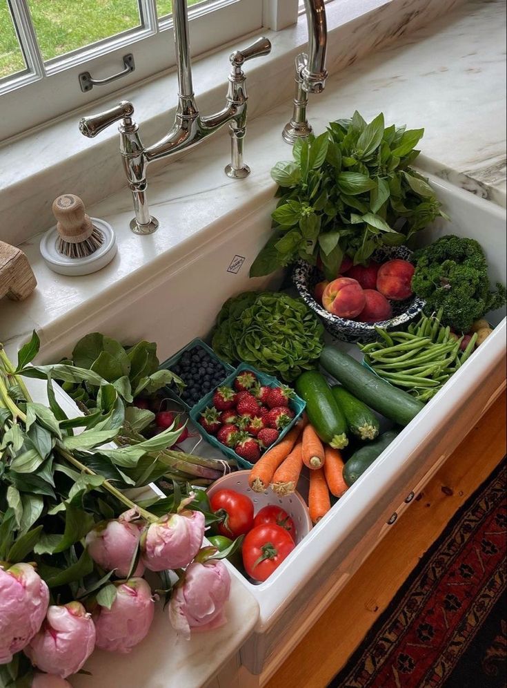 a kitchen sink filled with lots of fresh vegetables