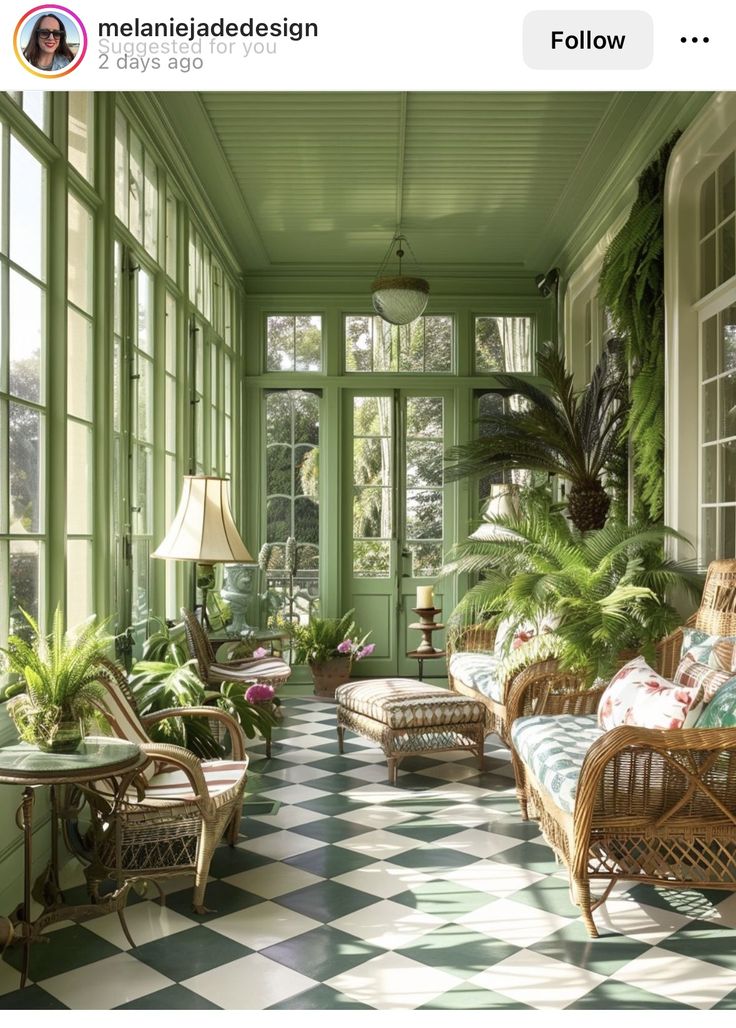 a room with green walls and lots of plants on the windows sill, chairs and tables