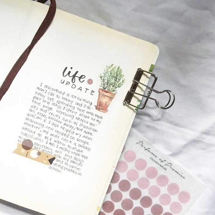 an open notebook sitting on top of a bed next to a clipboard with writing