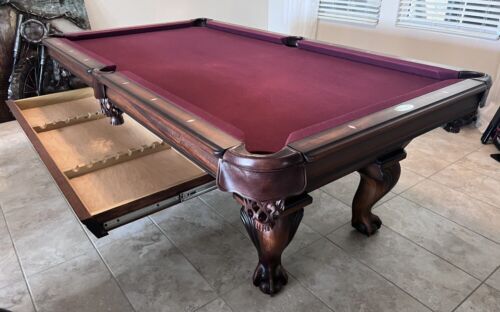 a pool table with an open drawer underneath it