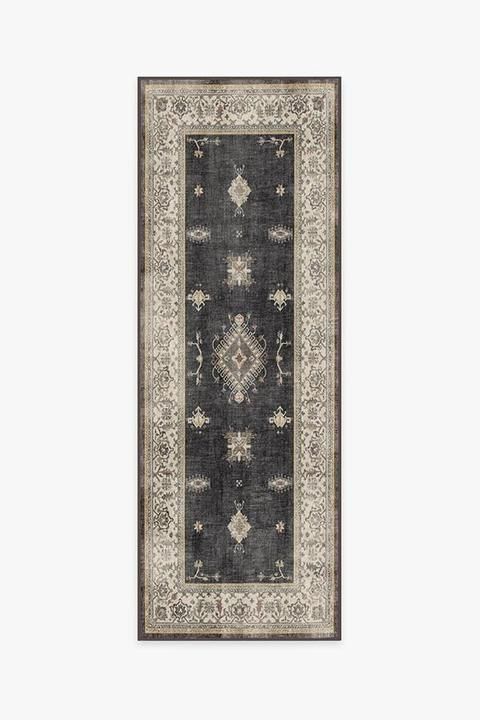 a rug with an ornate design on the bottom, and a border in grey tones