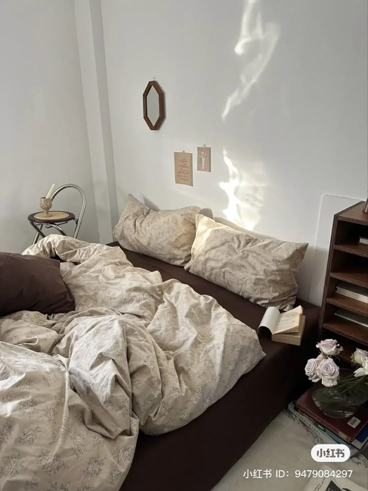 an unmade bed in a bedroom with white walls and brown linens on it