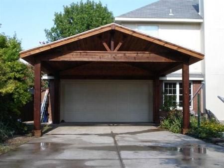 a garage with a wooden roof and two cars parked in the driveway