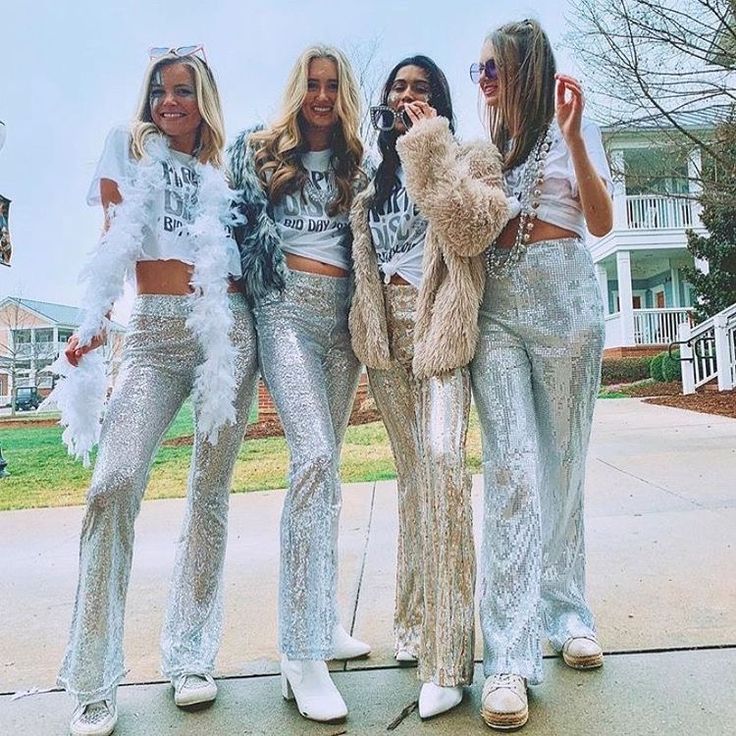 three women in sequin pants posing with a teddy bear