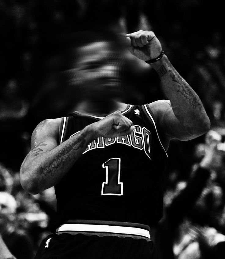 a black and white photo of a basketball player holding his fist up in the air