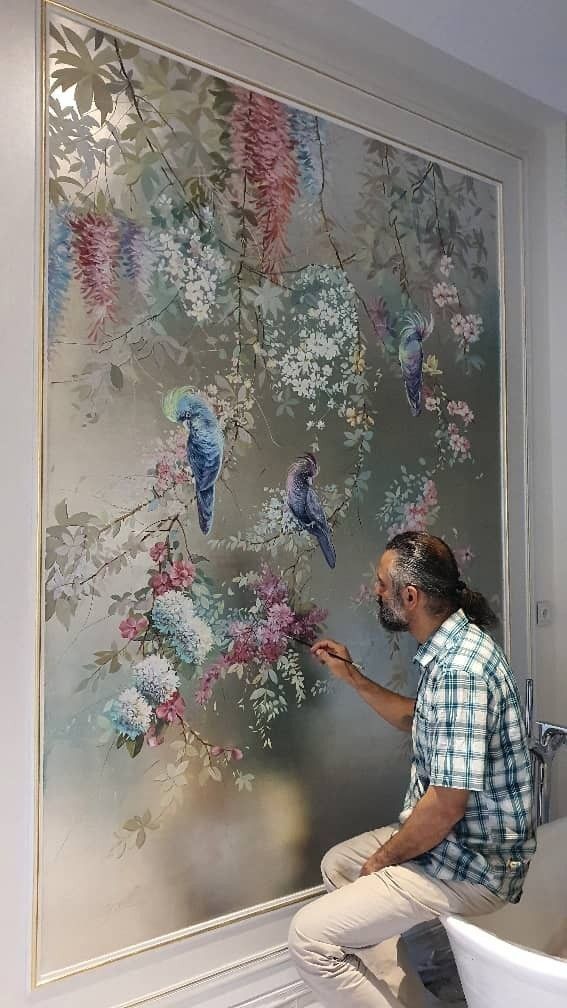 a man is painting flowers on the wall