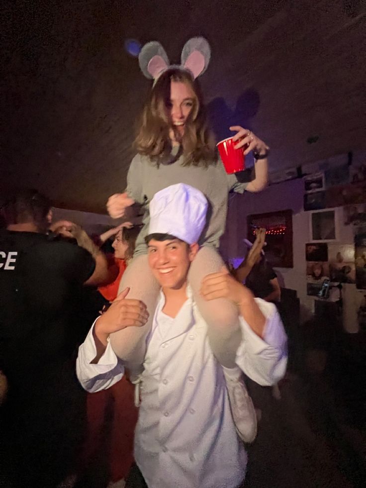 a woman is holding onto a man in bunny ears while they are dressed as chefs