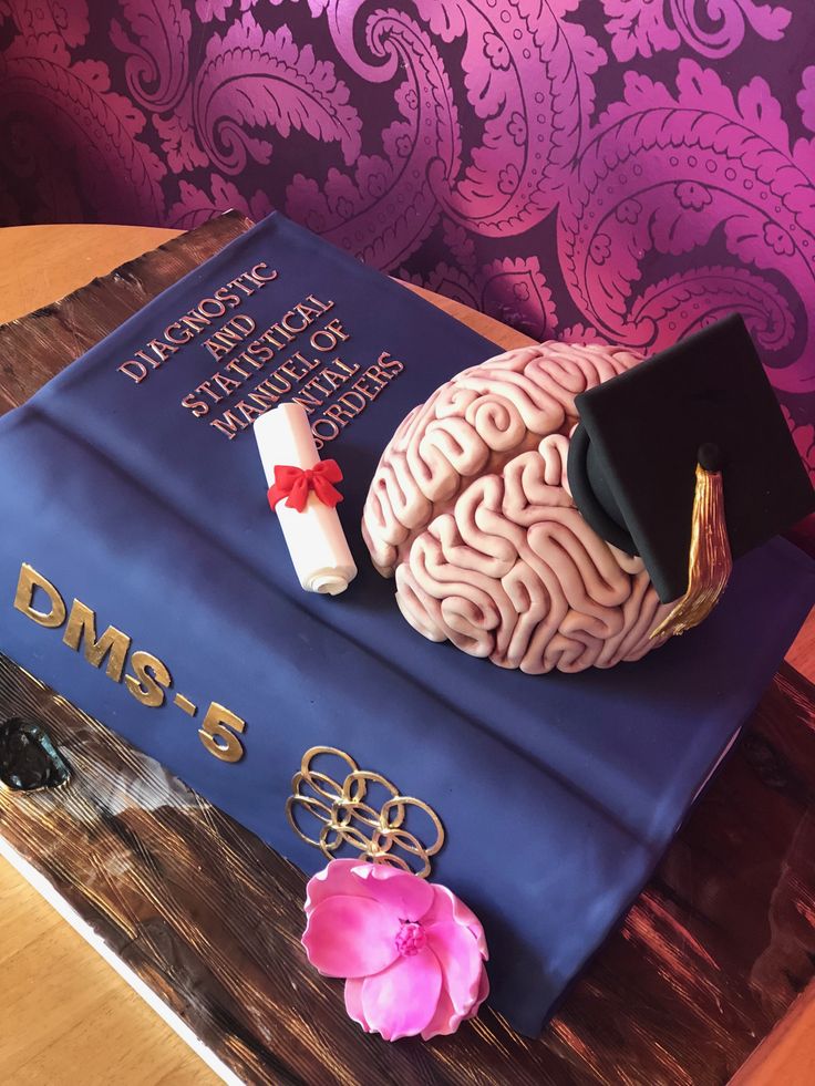 a cake made to look like a book with a graduation cap and diploma on top