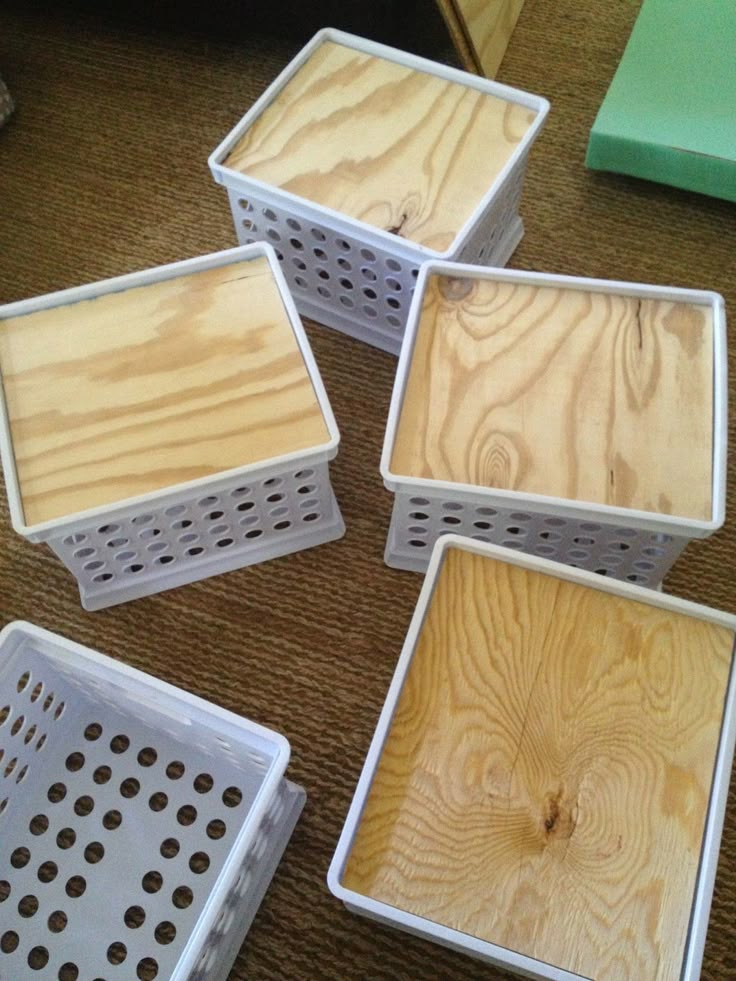 four wooden boxes sitting on the floor with holes in them