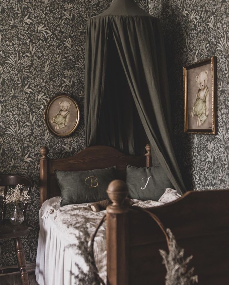 a bed with a canopy over it next to two framed pictures on the wall above it