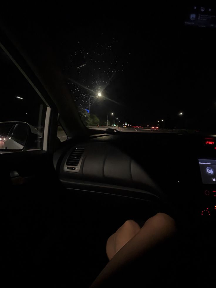 the interior of a car at night with fireworks in the sky