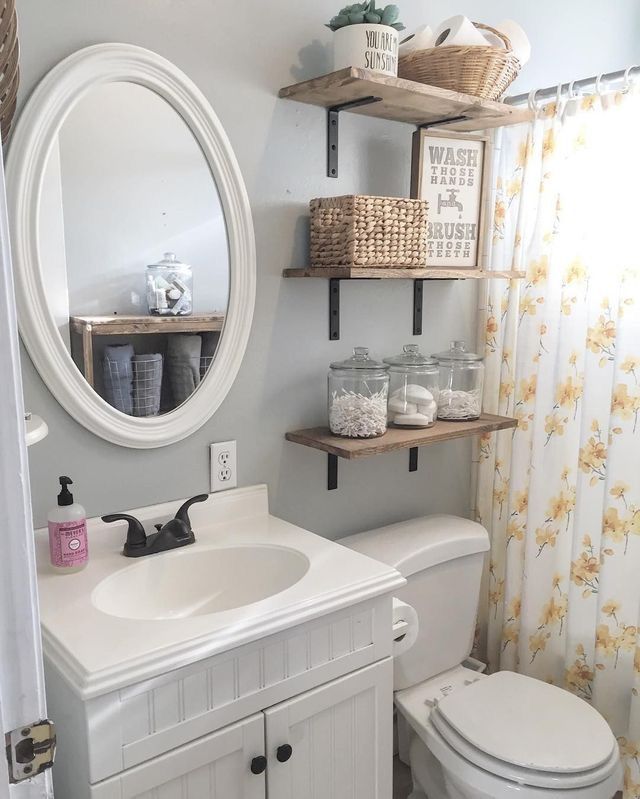 a white toilet sitting next to a bathroom sink under a mirror and shelf above it