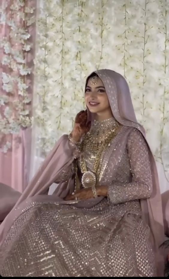 a woman sitting on top of a bed in a wedding dress