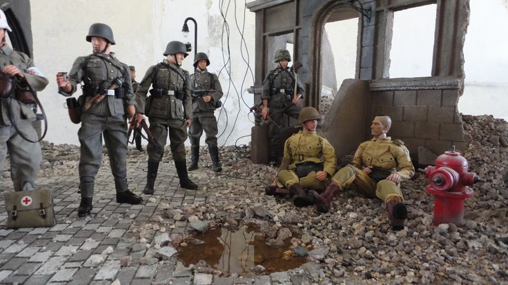 toy soldiers are sitting on the ground in front of a fire hydrant and building