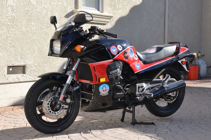 a red and black motorcycle parked in front of a building