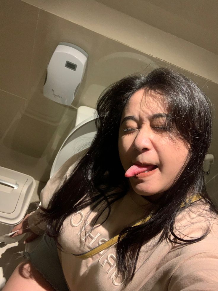 a woman sticking her tongue out in the bathroom