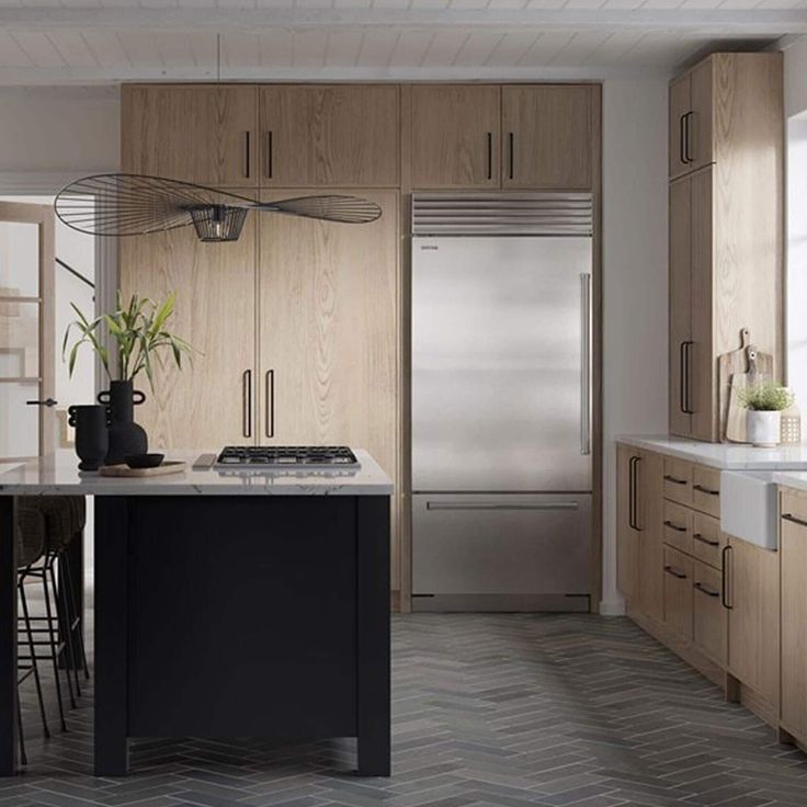 a kitchen with wooden cabinets and stainless steel appliances in the center, along with an island