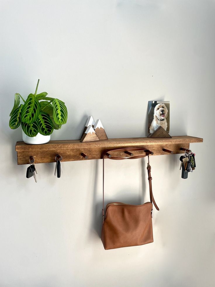 a wooden shelf with two purses and a plant on it