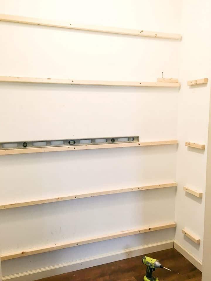 a room that has some shelves on the wall and a paint roller in front of it