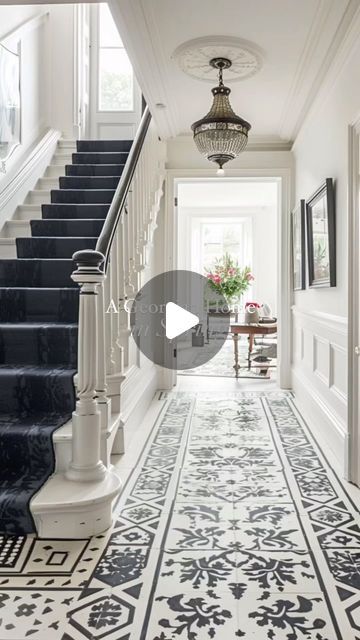 a hallway with black and white flooring, chandelier, and staircase leading up to the second floor