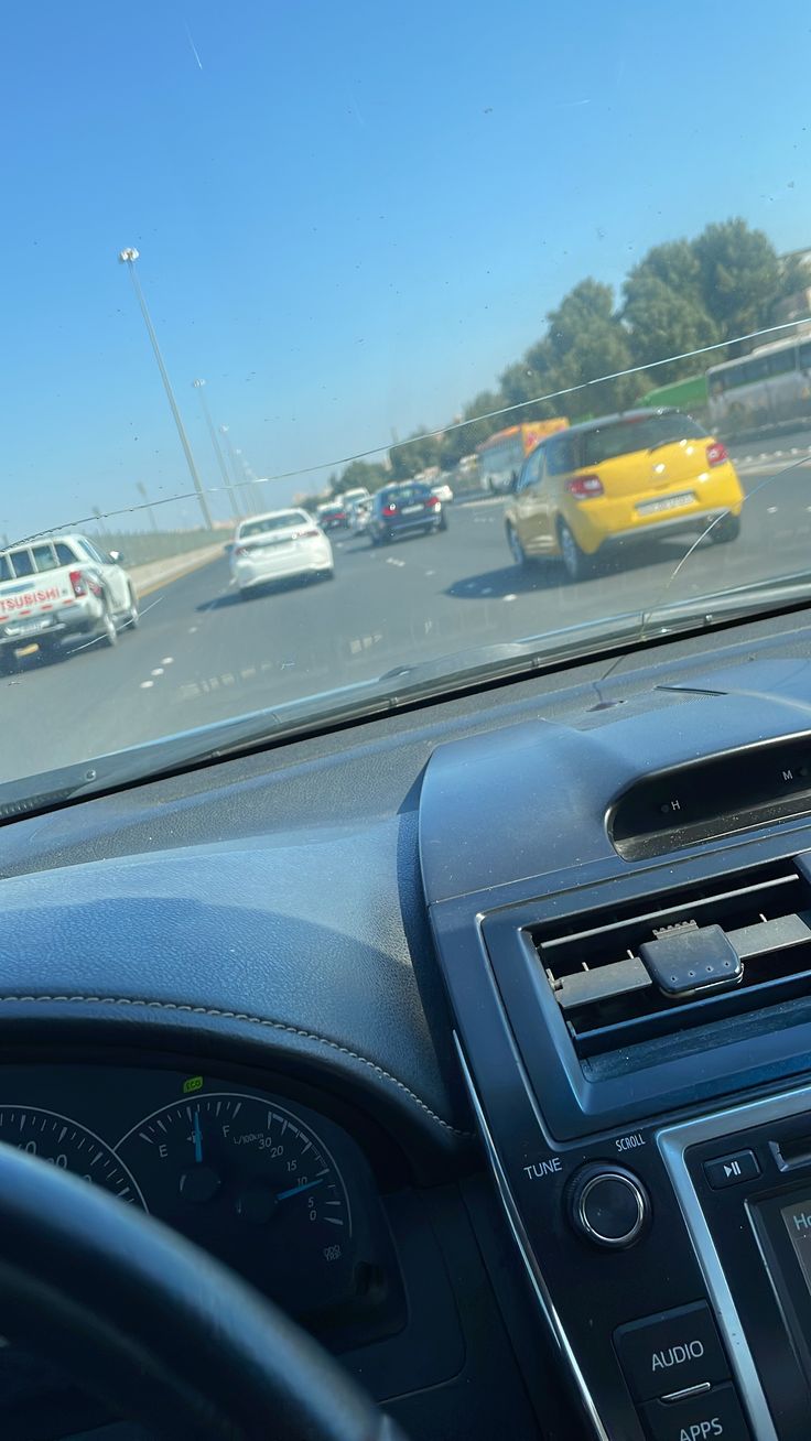 the dashboard of a car on a busy highway with traffic in the backgroud