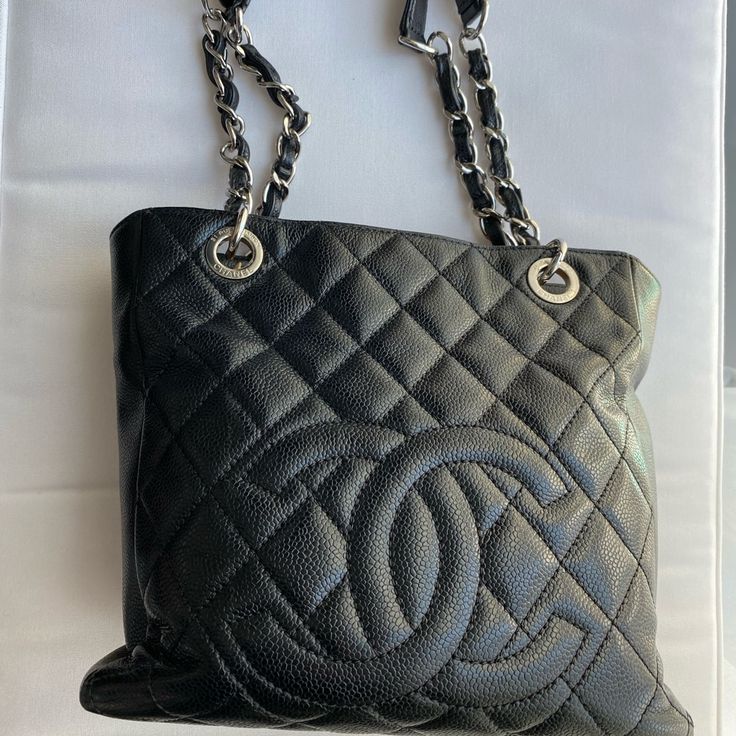 Chanel Tote Timeless Petite Shopper Ghw Black Caviar Leather Shoulder Bag, Accented With Silver Chain Hardware. Pre-Owned, Excellent Condition. Gently Used For Special Occasions. Black Caviar Leather, Silver-Tone Hardware, Double Chain-Link And Leather Shoulder Straps, Cc Accent At Front, Exterior Back Flat Pocket, Fabric Interior Lining With One Zipper Pocket And One Flat Pocket, Magnetic Snap Tab Closure. Measurements: Body Length 9.75" Height 9.5" Width 3.5" Drop Handle 9.25" Chanel Gst, Chanel Coco Handle, Vintage Chanel Bag, Chanel Jumbo, Chanel Tote, Chanel Purse, Black Caviar, Black Leather Bags, Double Chain