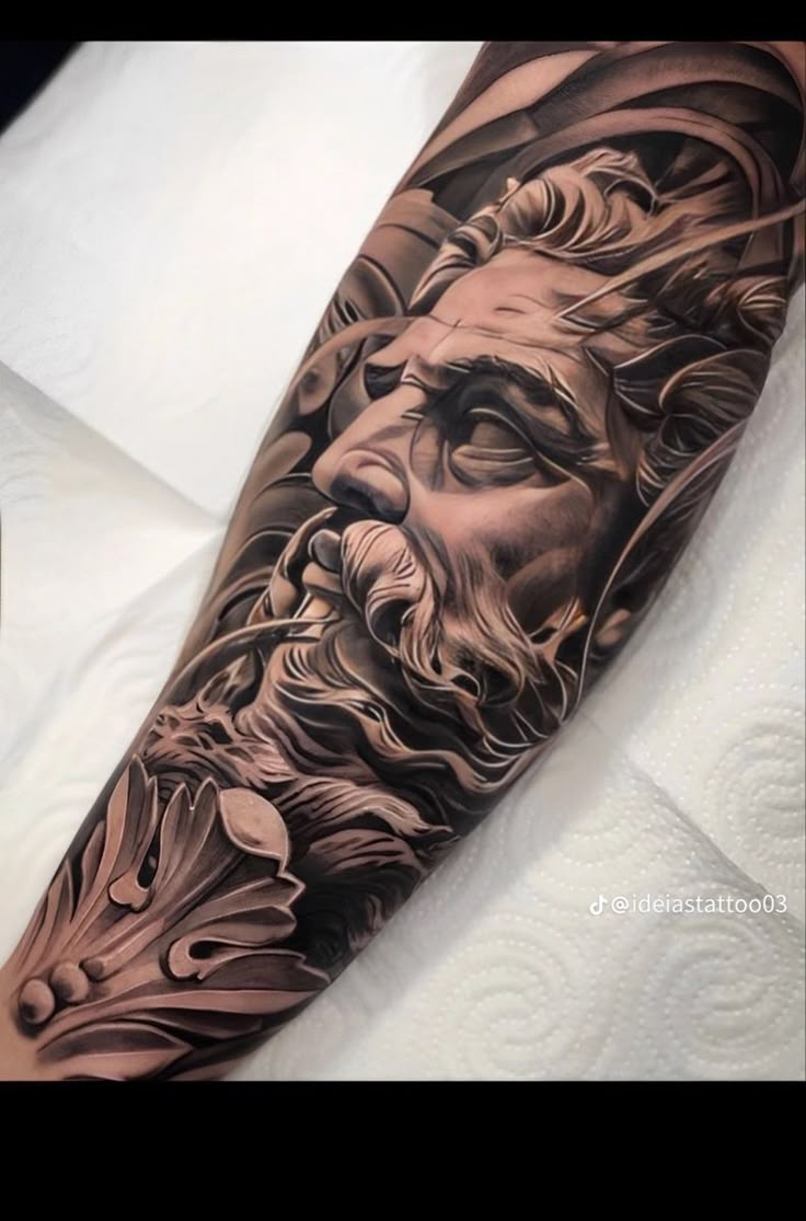 a man's arm with a black and grey tattoo on it, depicting the face of jesus