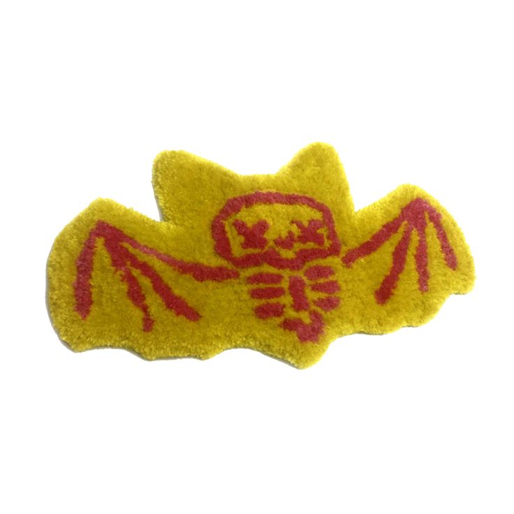 a yellow and red embroidered patch with a skeleton on it's back, in front of a white background