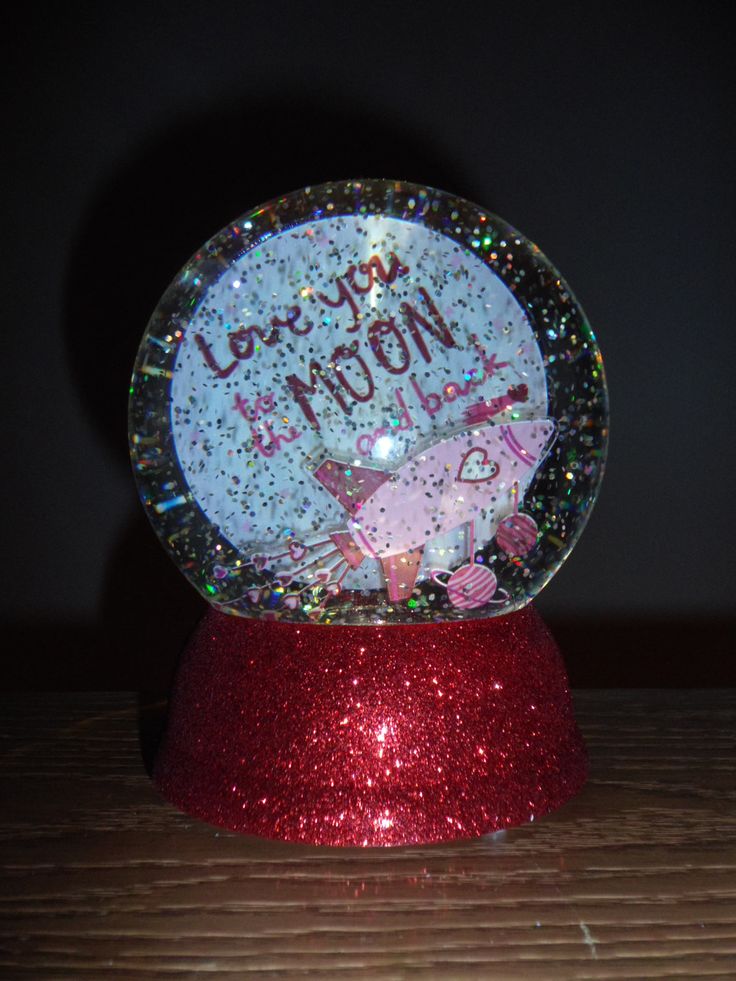 a snow globe with the words love you mom written in it on a red base