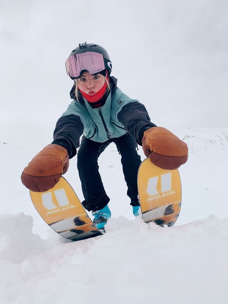 a person riding a snow board on a snowy surface with their feet in the air