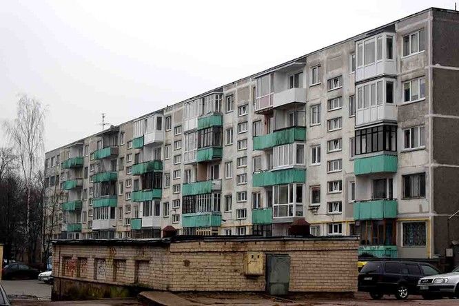 an apartment building with green balconies on the top and blue balconies on the bottom